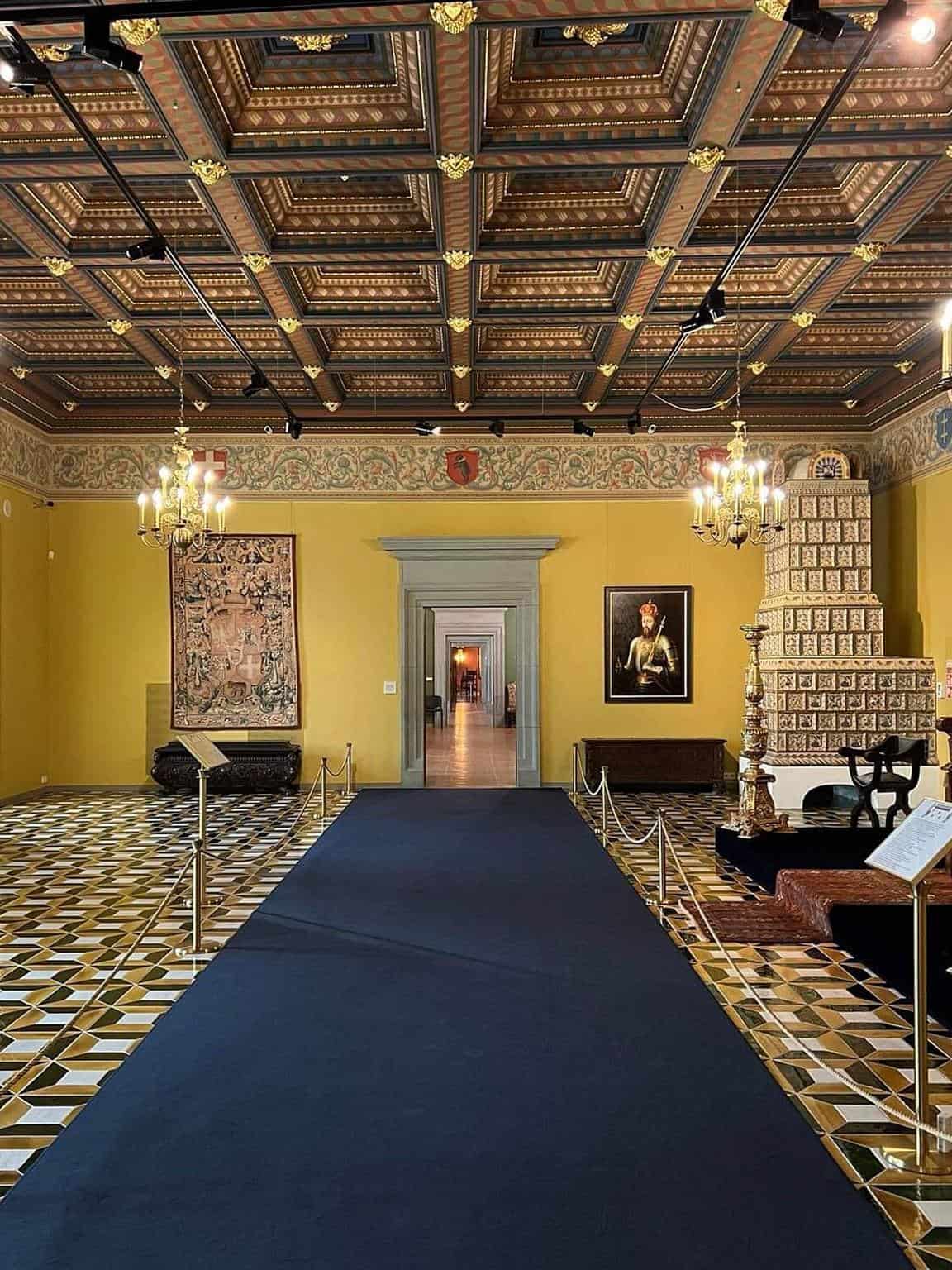 Intricate historic room with ornate ceiling, decorative walls, and cultural artwork at Quest For Directions.