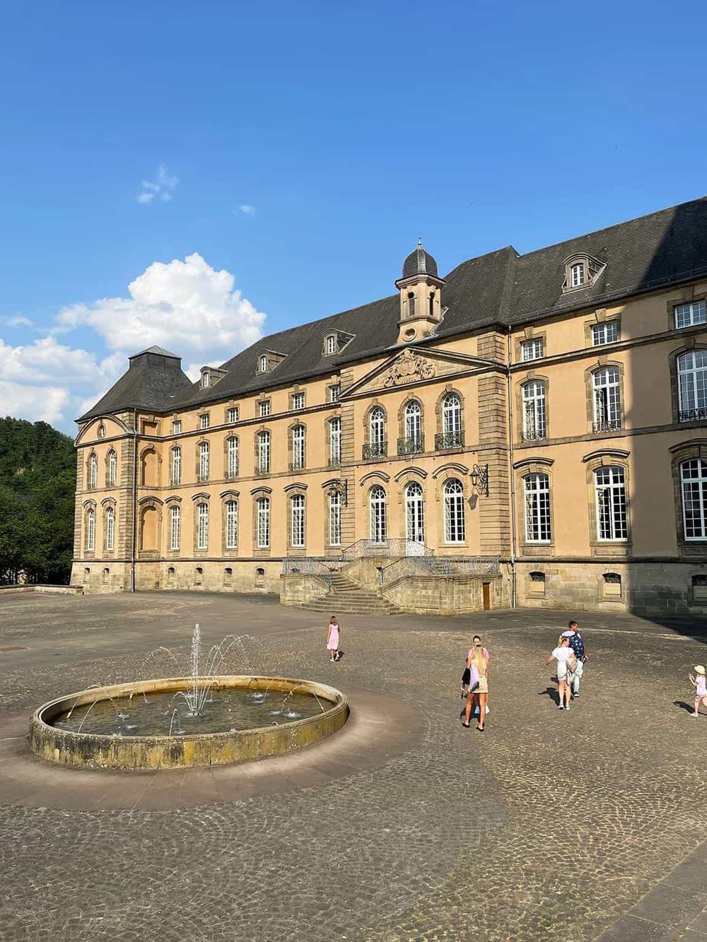 Elegant historic castle with fountain, popular tourist destination, beautiful architecture, scenic outdoor setting, QuestForDirections.