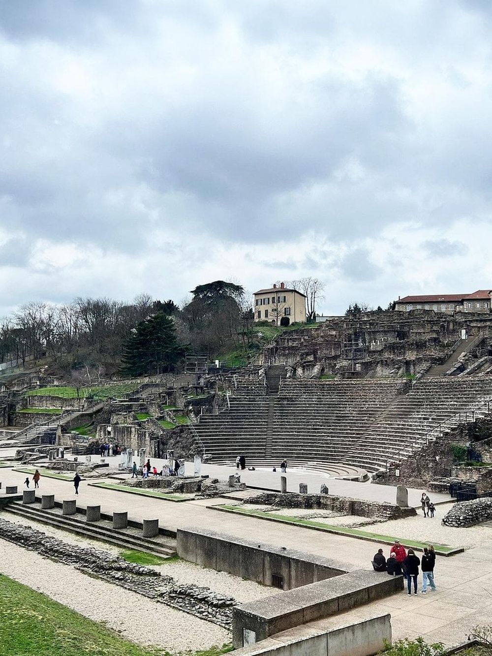Ancient Roman Amphitheater in Verona, Italy, under cloudy sky, popular historical tourist destination.