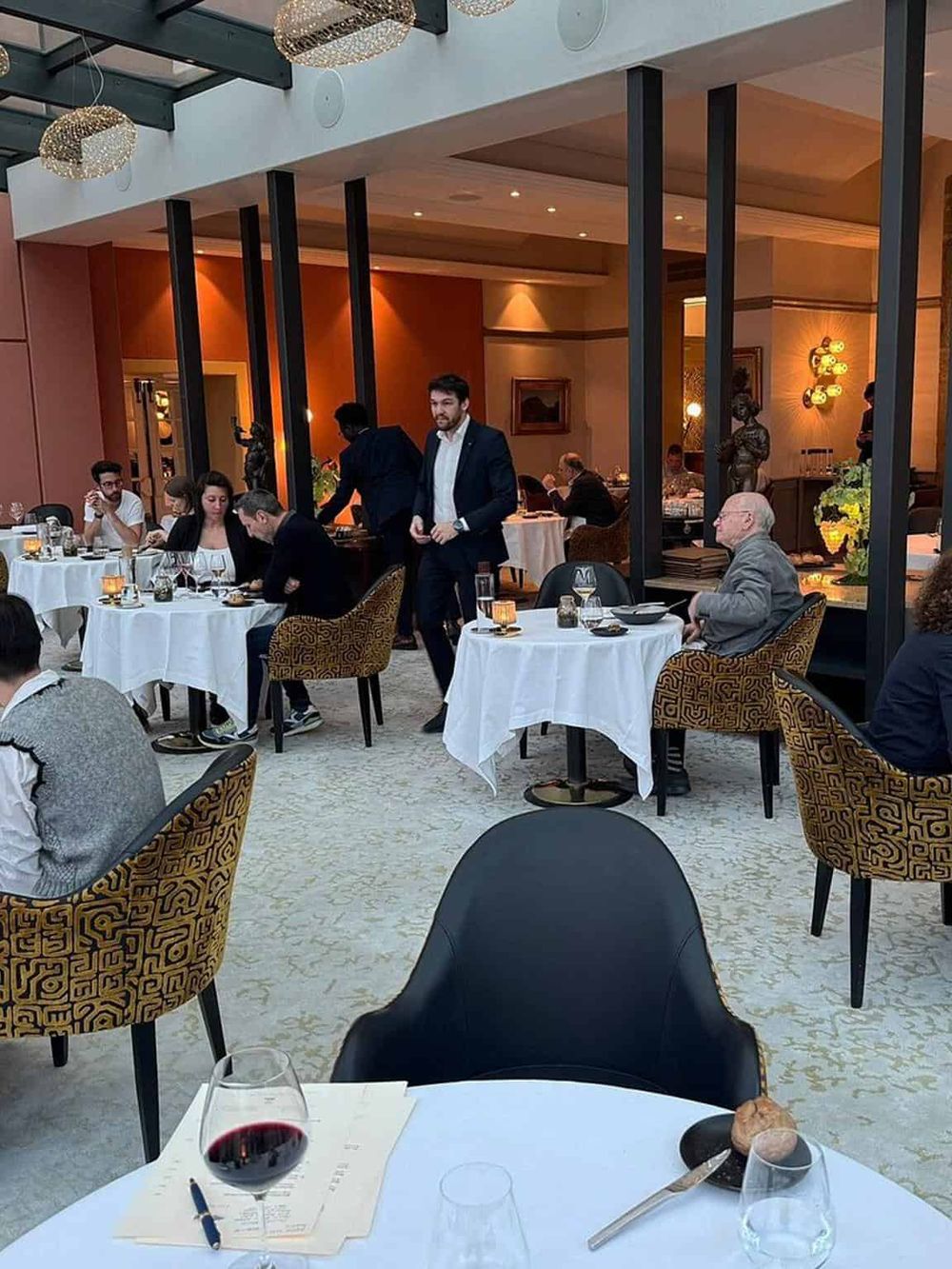 Elegant restaurant interior with guests enjoying fine dining at QuestForDirections. Stylish decor and attentive service create a sophisticated ambiance.