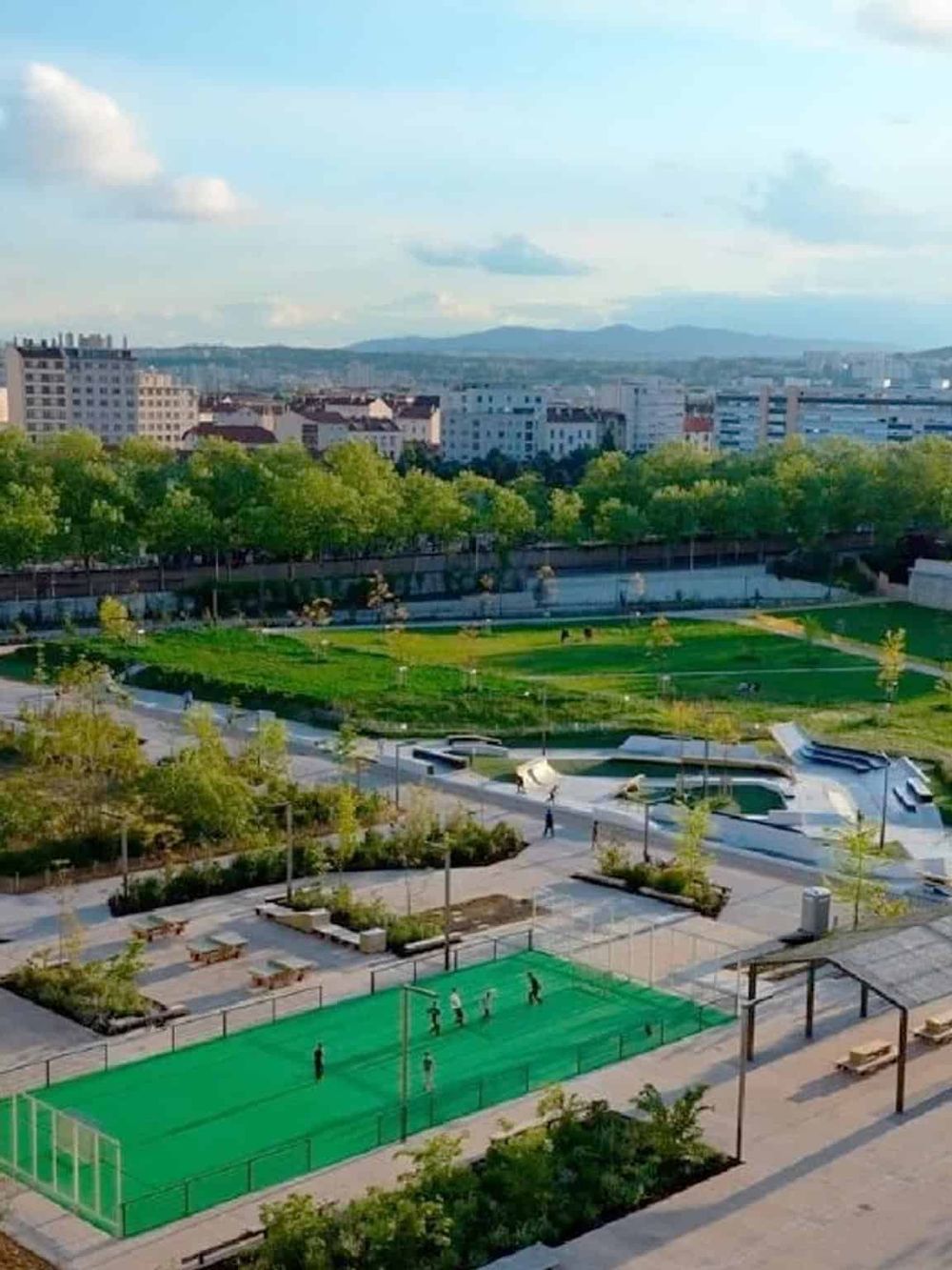 Modern urban park with sports courts and green spaces in the city center.
