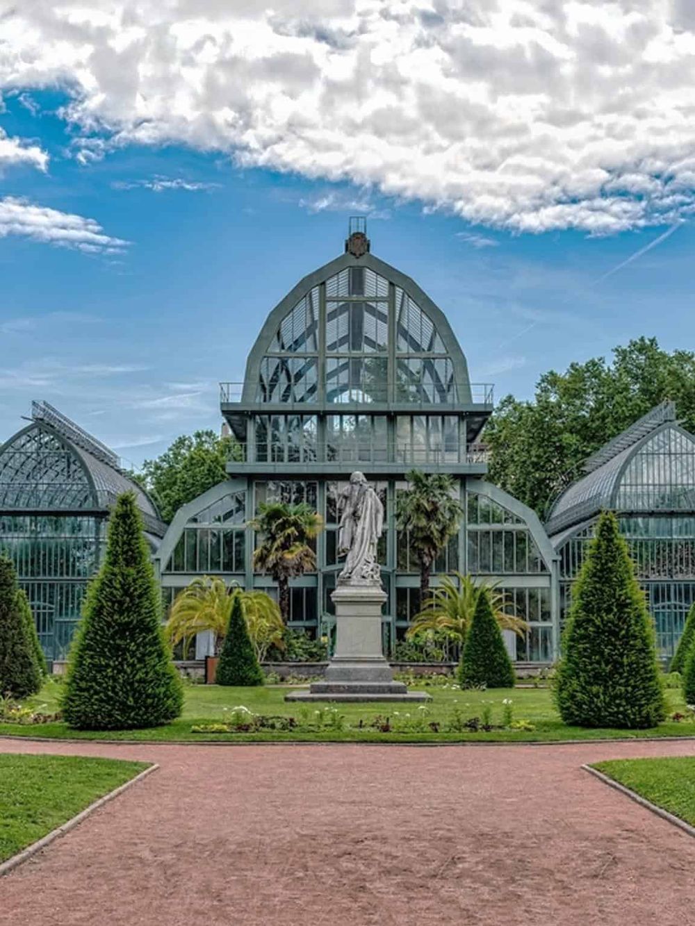 Elegant glass botanical greenhouse at Quest For Directions botanical garden, featuring lush greenery and scenic pathways.