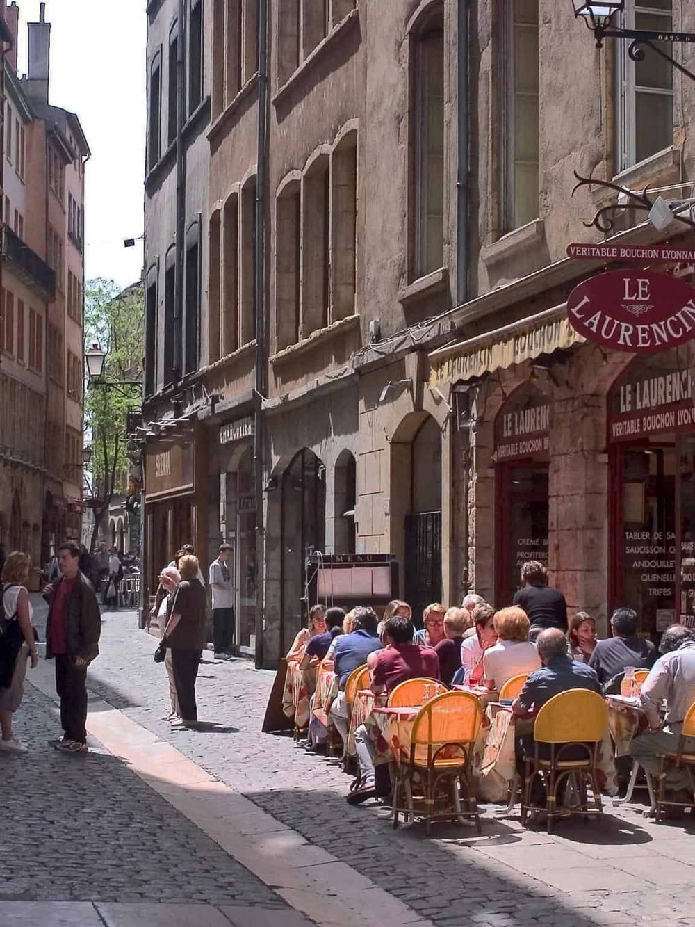 Charming outdoor cafe scene on a cobblestone street in Old Lyon, France, perfect for exploring historic districts.
