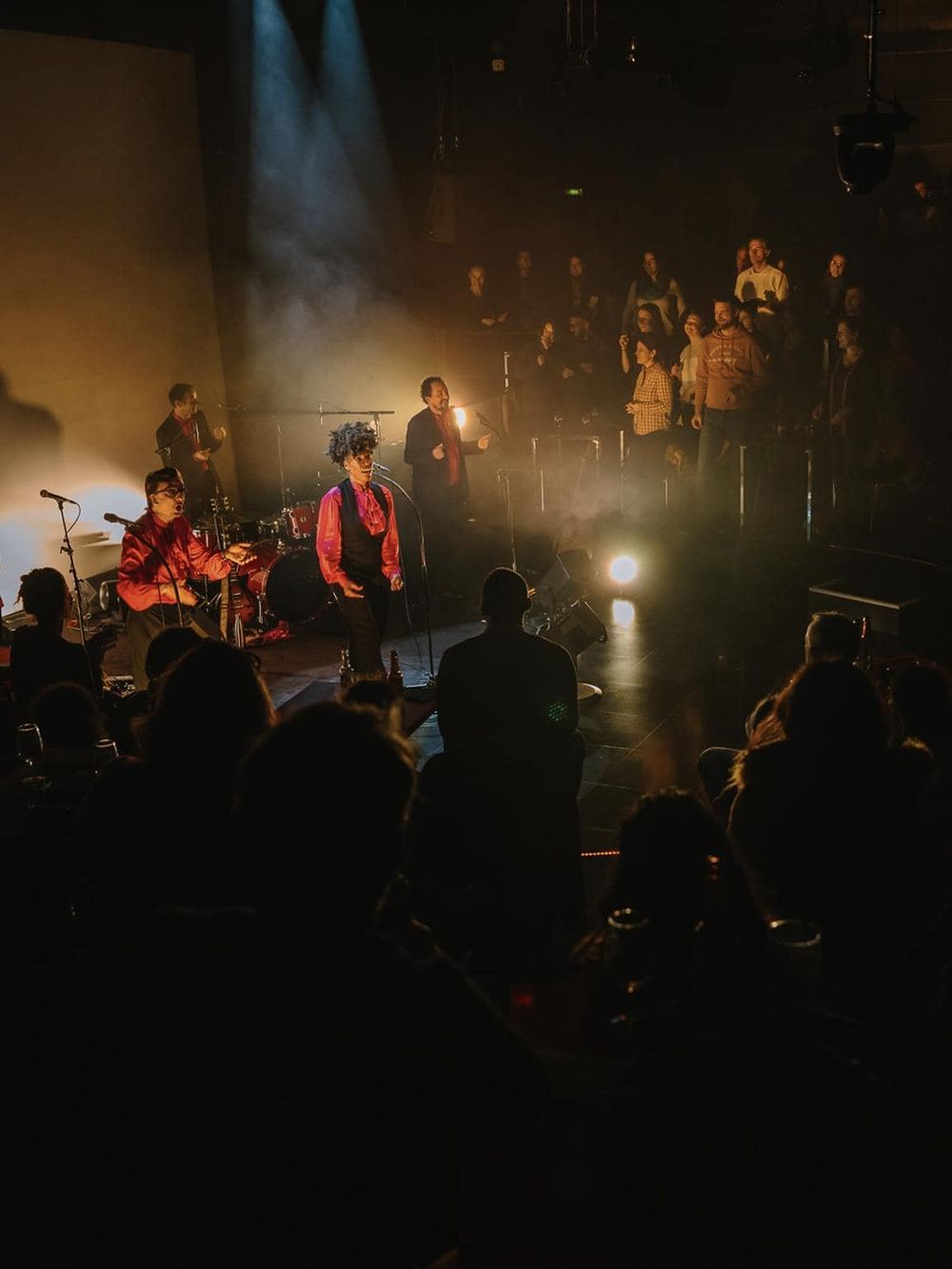 Vibrant live music performance at QuestforDirections event in a dark venue with an enthusiastic crowd.