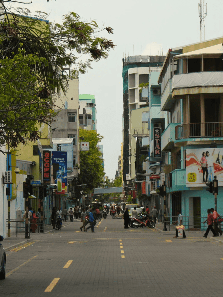 Busy city street with colorful buildings and pedestrians in the downtown area.