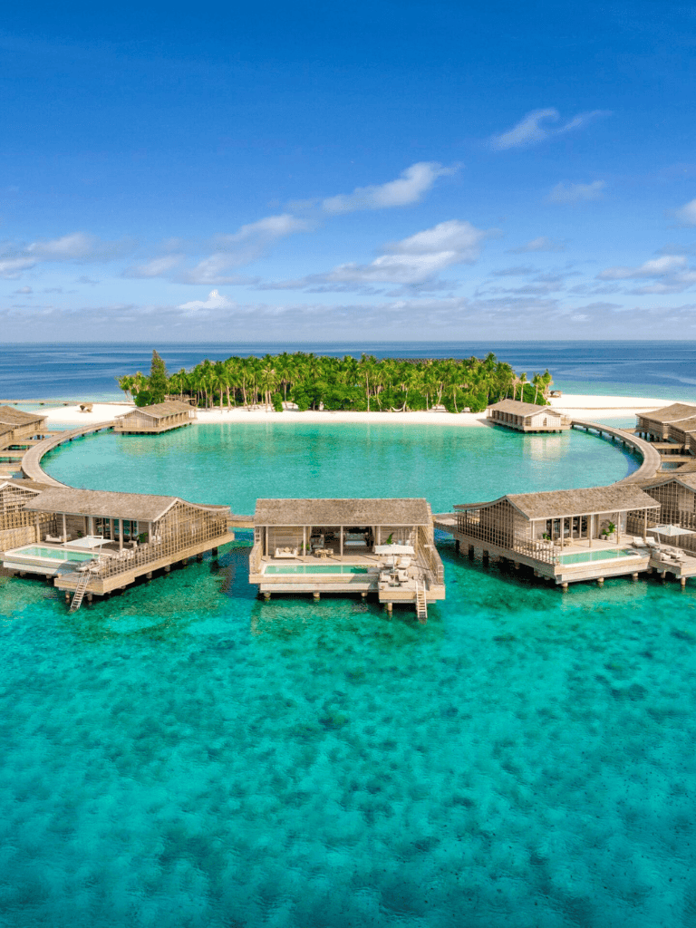 Overwater bungalows with private pools at a tropical resort on a clear blue ocean day.