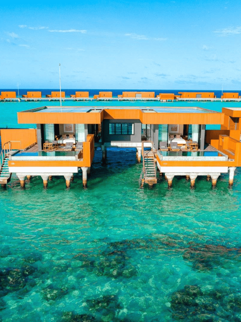 Overwater bungalow with turquoise waters and stunning ocean view, ideal for luxury island vacations.