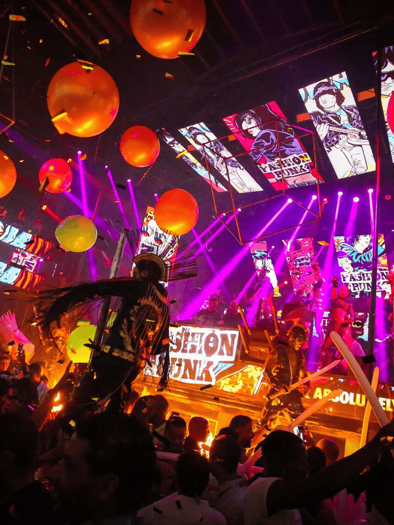 Vibrant music event with colorful lights, stage performances, and lively crowd at QuestForDirections.