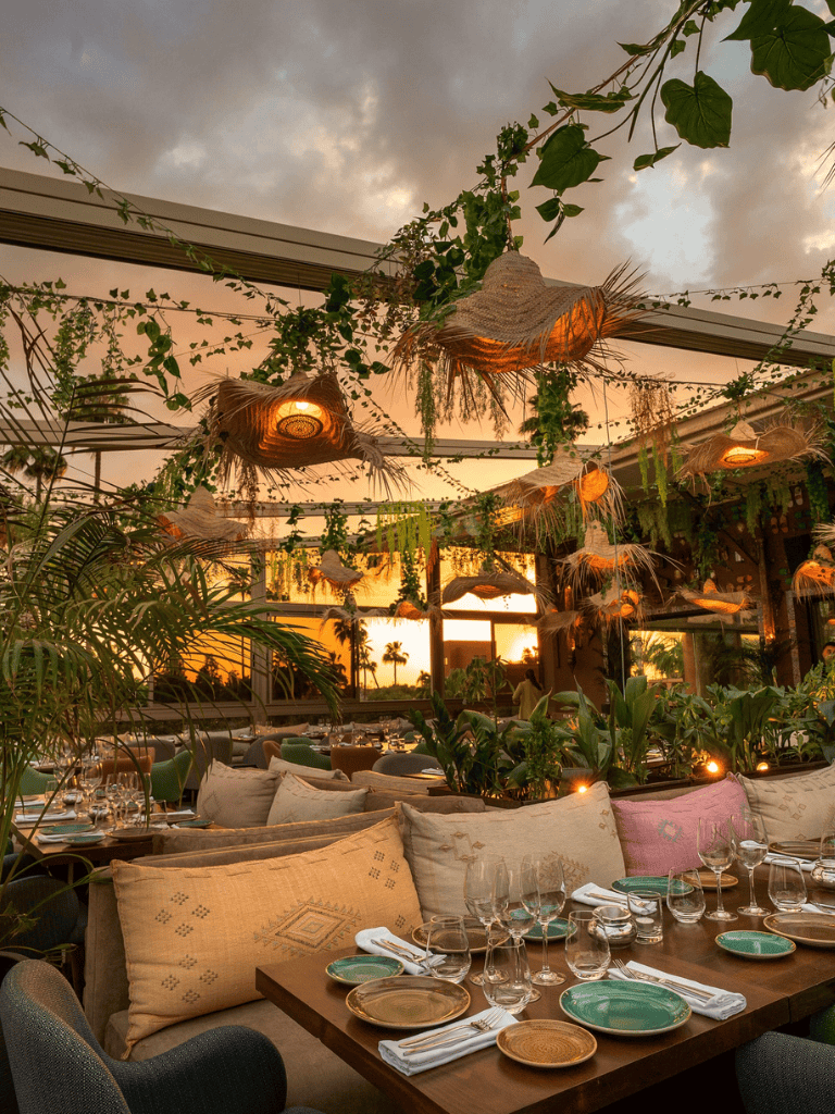 Sunset outdoor dining with lush tropical decor and bohemian accents at QuestForDirections.