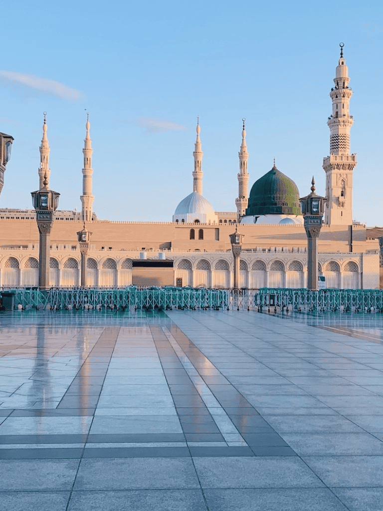 Serene view of Al-Masjid an-Nabawi in Medina during daytime with clear sky.