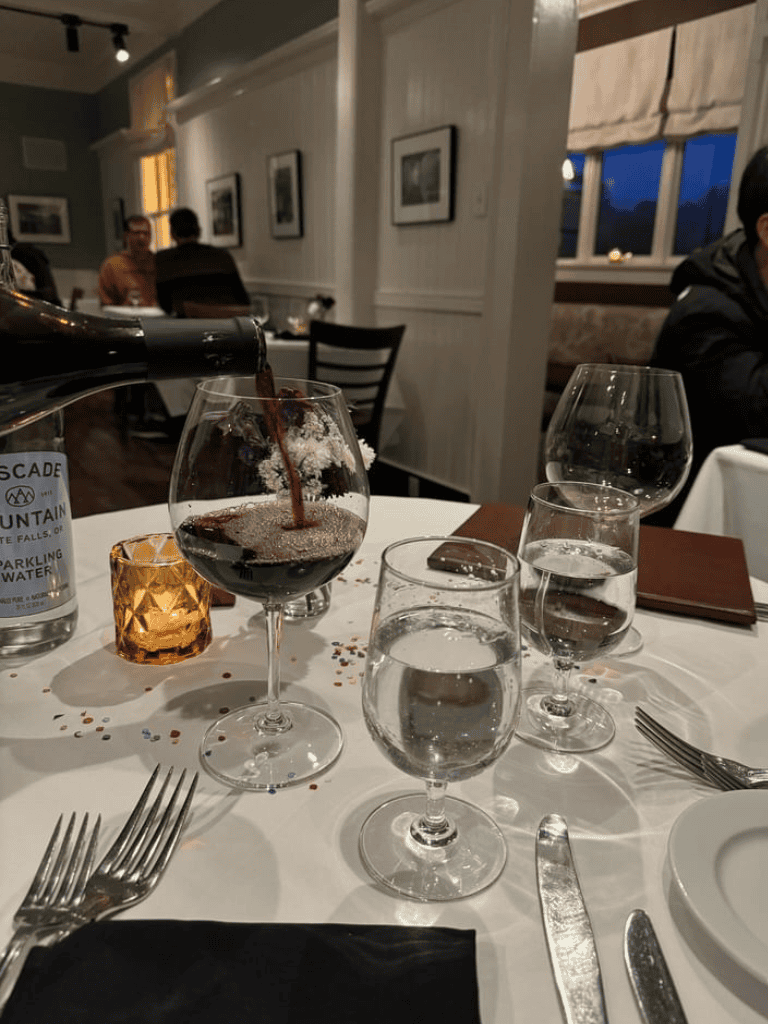 Refreshing water poured into a wine glass at a restaurant dinner table.