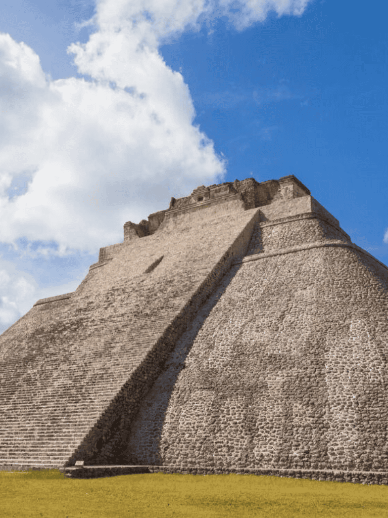 Ancient Mayan pyramid at Chichen Itza in Mexico with bright blue sky in the background.