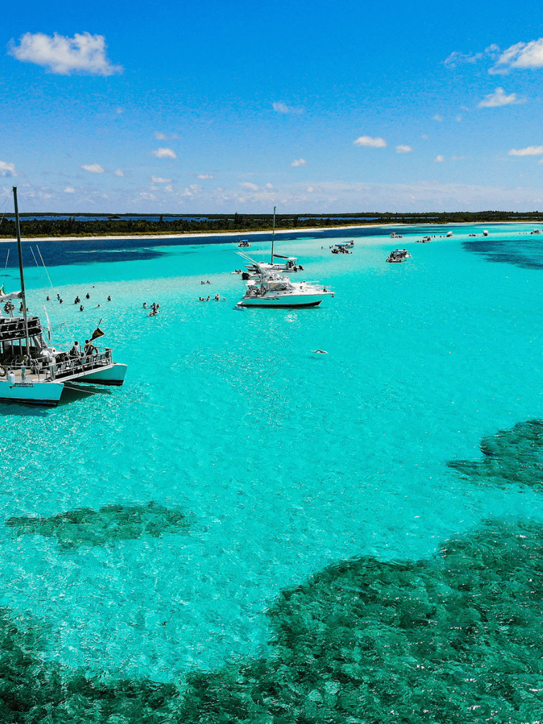 Pristine turquoise waters with boats and swimmers, perfect for relaxing and exploring Florida Keys.