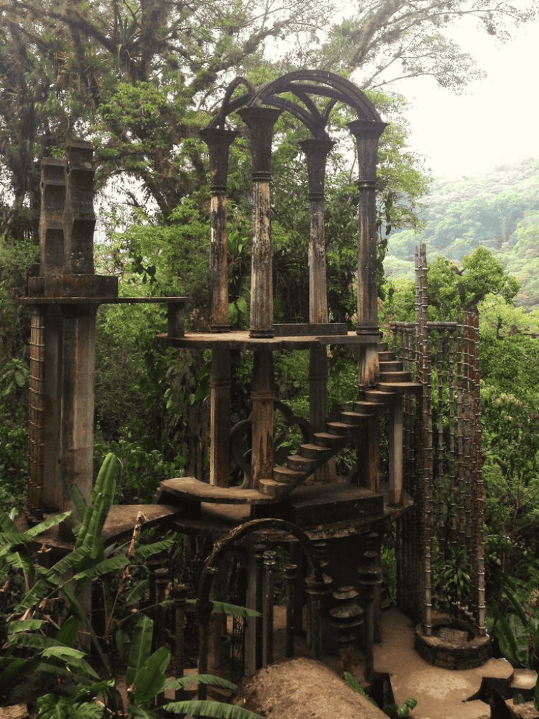 Ancient ruins of a wooden gazebo in lush jungle, overgrown with greenery and vines, on QuestForDirections site.
