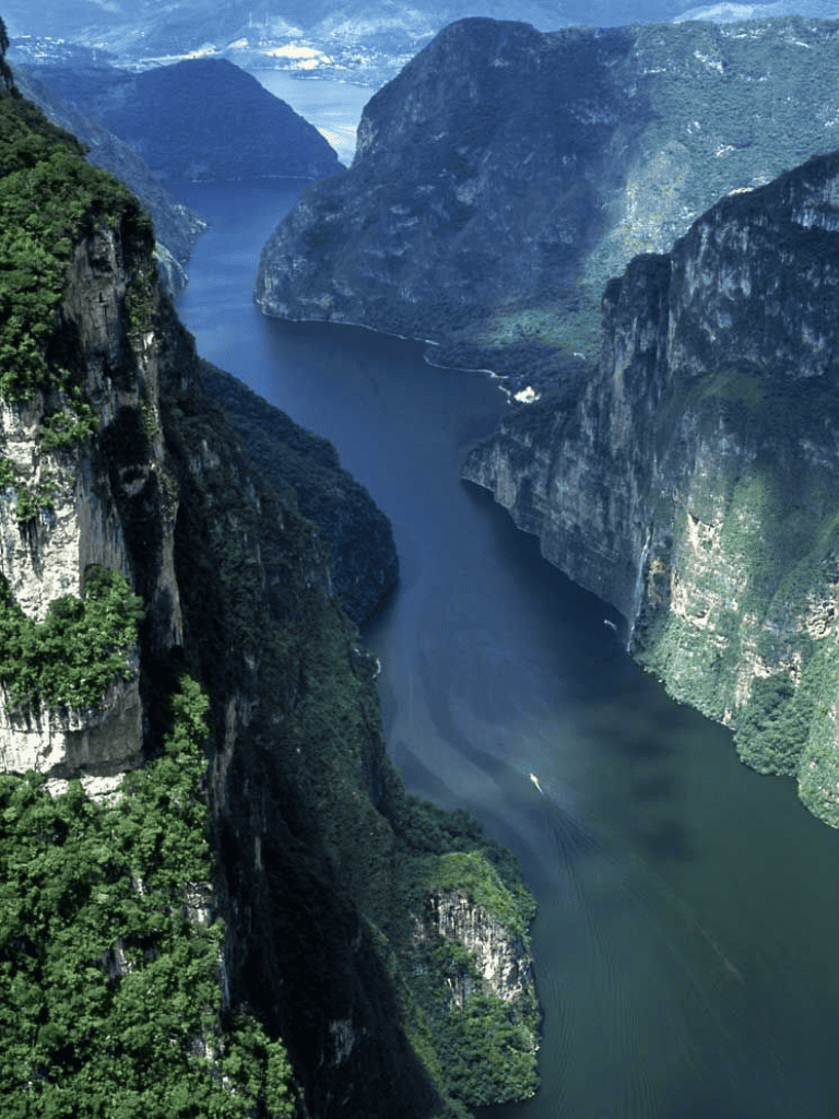 Serene river valley with lush green cliffs and deep waterway, scenic landscape, nature travel destination, Quest For Directions.