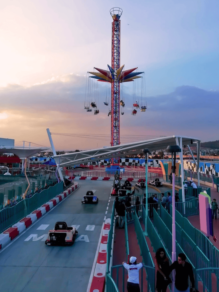 Bright amusement park with swing ride and mini race cars, great family entertainment, vibrant atmosphere, perfect for fun days out.