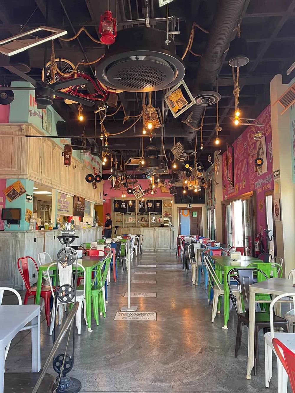 Colorful, vibrant restaurant interior with eclectic decor, lively atmosphere, and comfortable seating for diners.