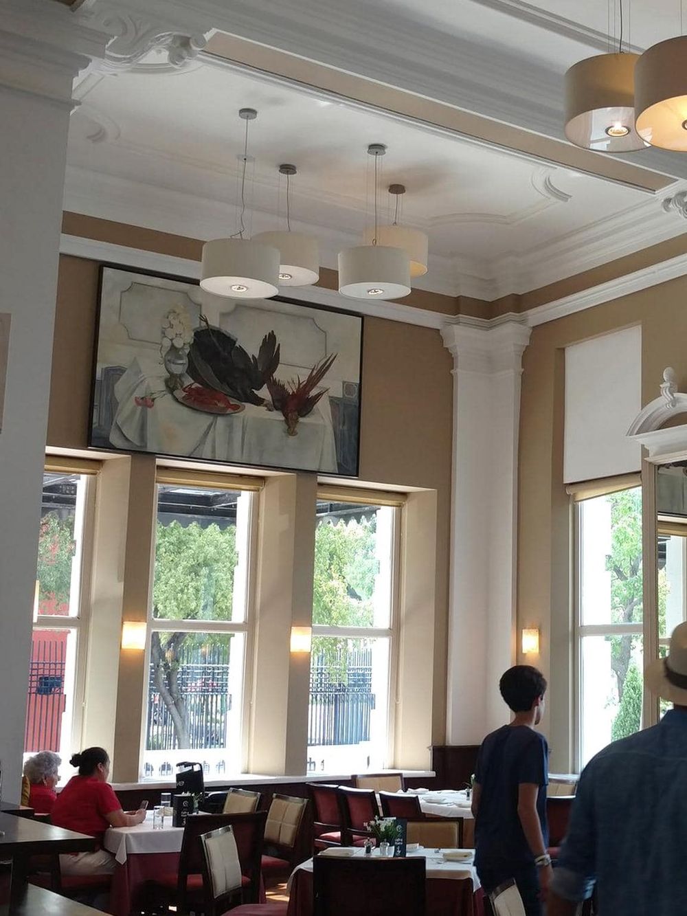 Elegant restaurant interior with large windows and classic decor.