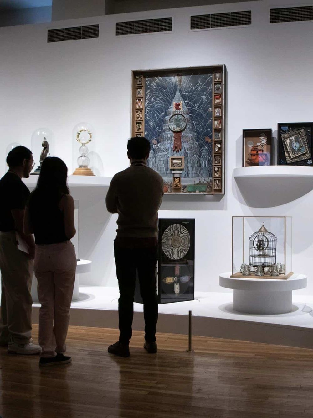 Intricate artwork and sculptures displayed in a modern art gallery, visitors exploring contemporary pieces and installation art.