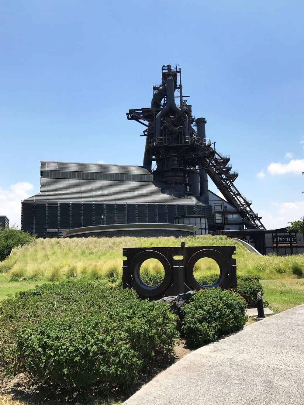 Historic industrial museum exhibit at Quest for Directions, showcasing a large black steel mining or factory structure.