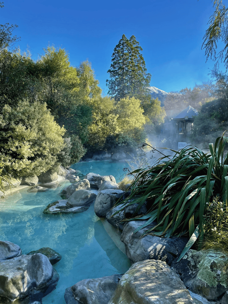 Serene hot springs surrounded by lush greenery and mountain views, perfect for relaxation and nature escape.