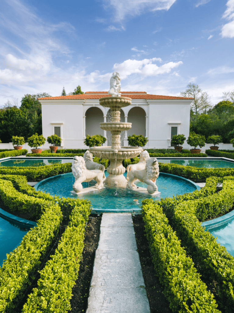 Elegant garden fountain with lion statues and lush landscaping at QuestForDirections estate.
