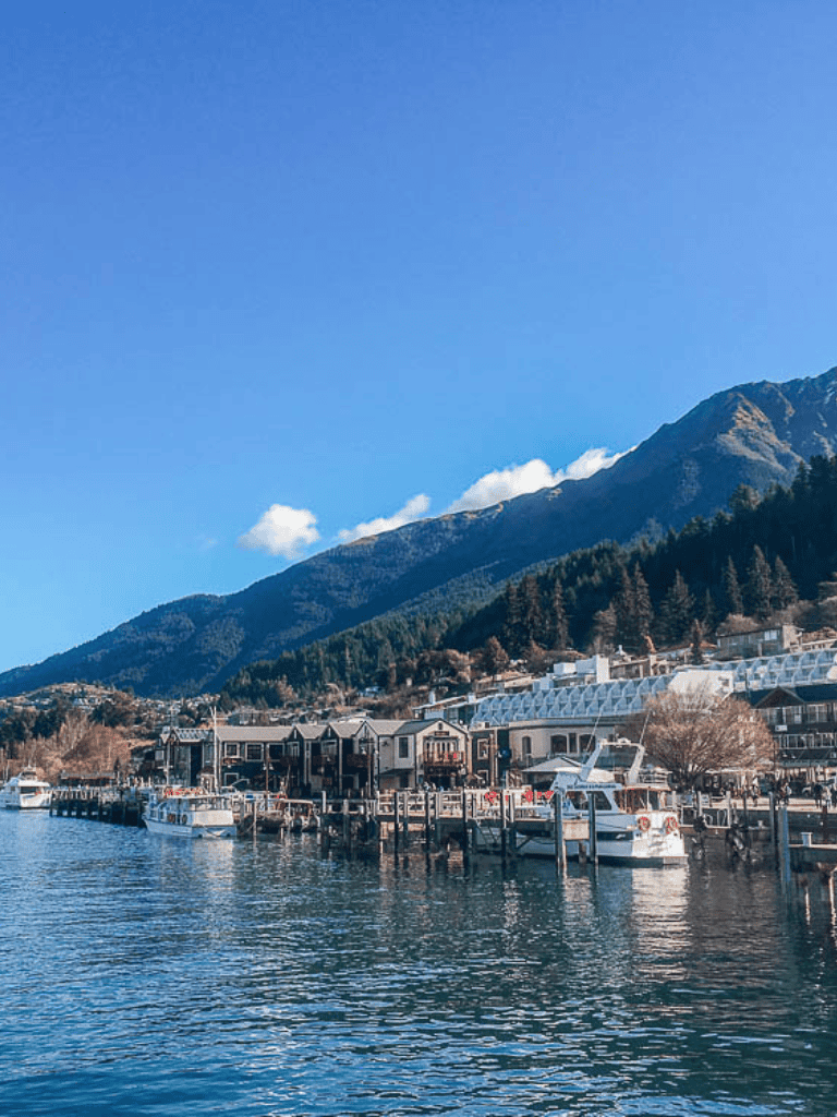 Serene waterfront with boats and mountains, perfect for travel planning and scenic adventures.