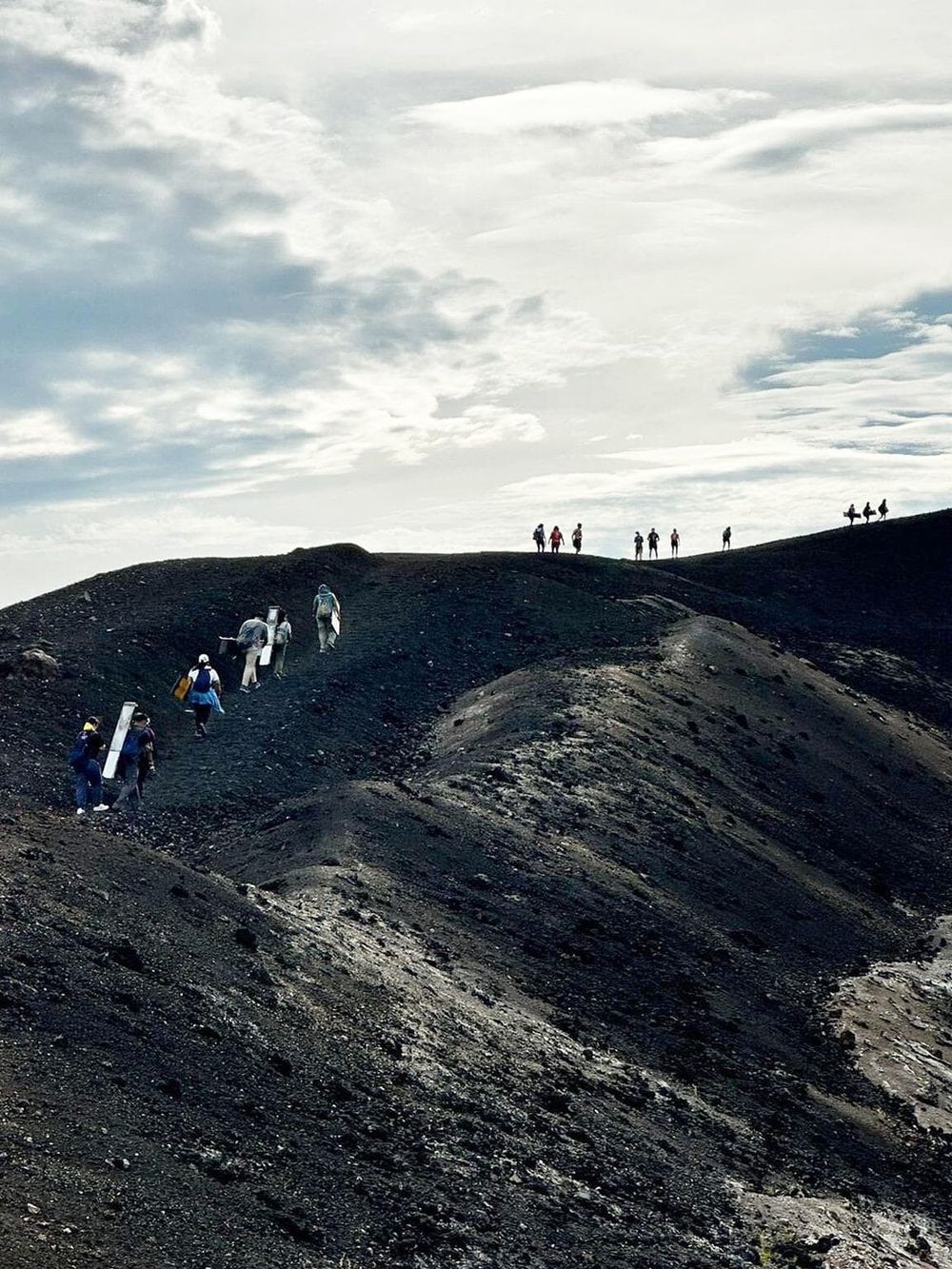 Hikers climbing volcanic mountain trail, scenic landscape, QuestForDirections outdoor adventure, travel, hiking, scenic mountain views.
