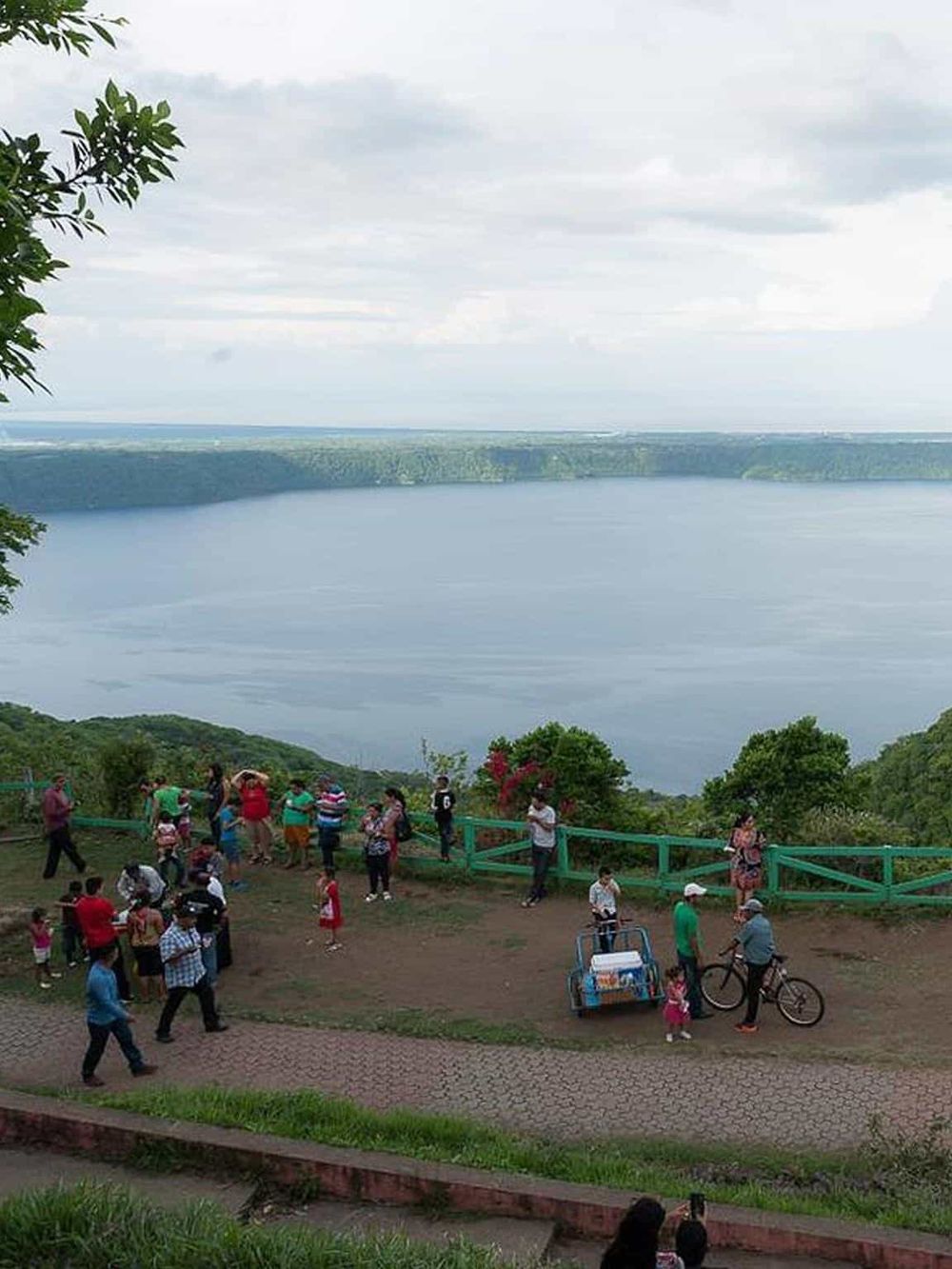 Breathtaking view of a large lake with a group of people enjoying the scenic lookout and nature experience.