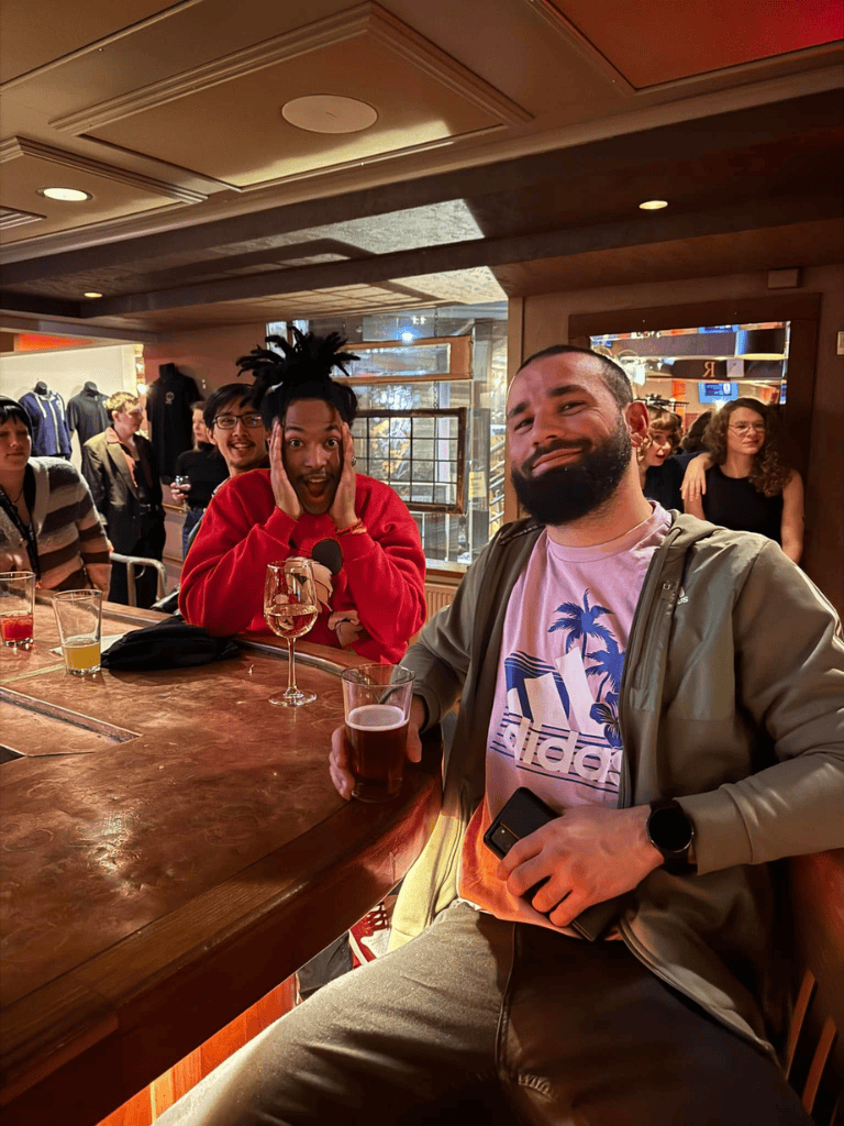 Cheerful group at bar enjoying drinks, casual social gathering, diverse friends, lively atmosphere.