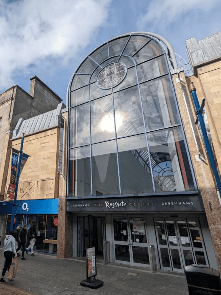 1. Modern glass entrance at The Kingsgate Centre in Debenhams, featuring contemporary architecture.