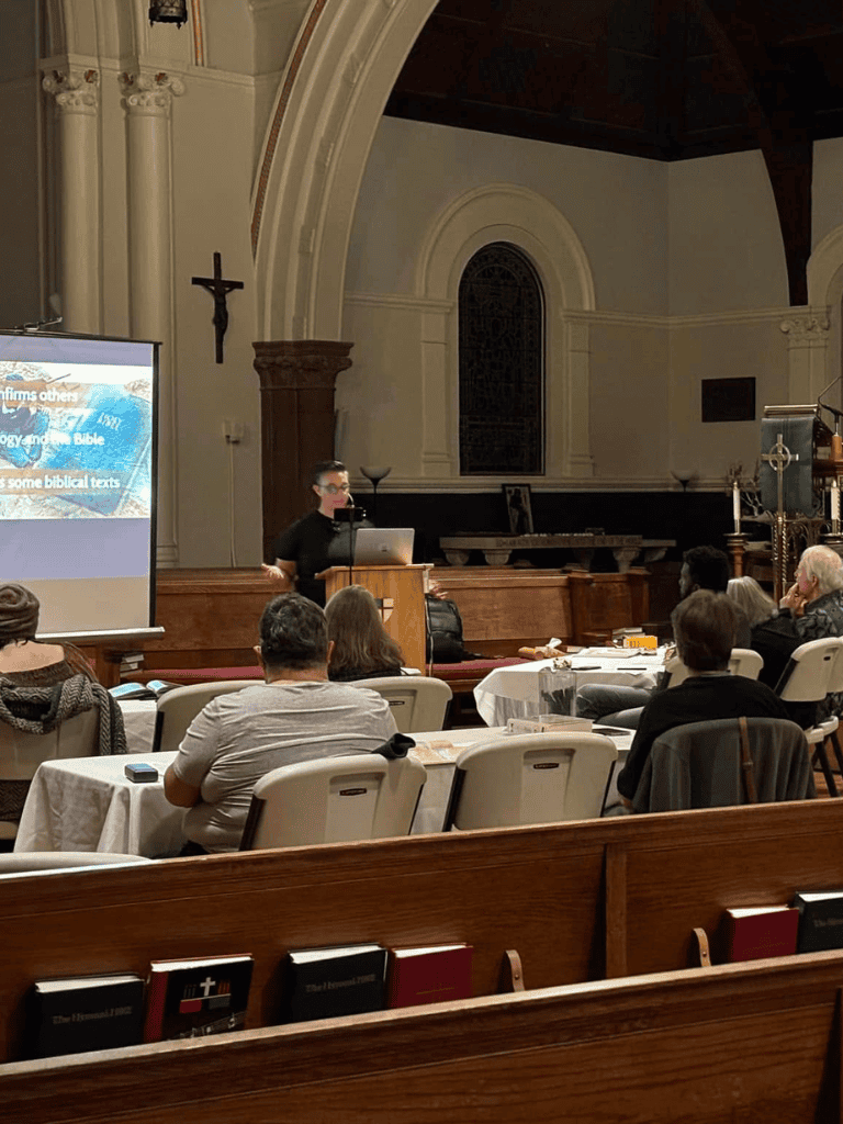 Accessible church interior with speaker presenting biblical teachings to engaged attendees.