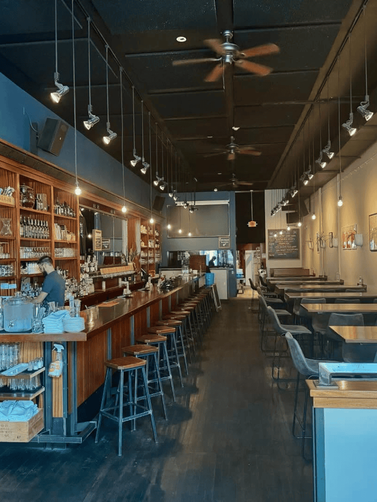 Cozy modern bar interior with wooden accents and warm lighting, ideal for socializing and casual dining.