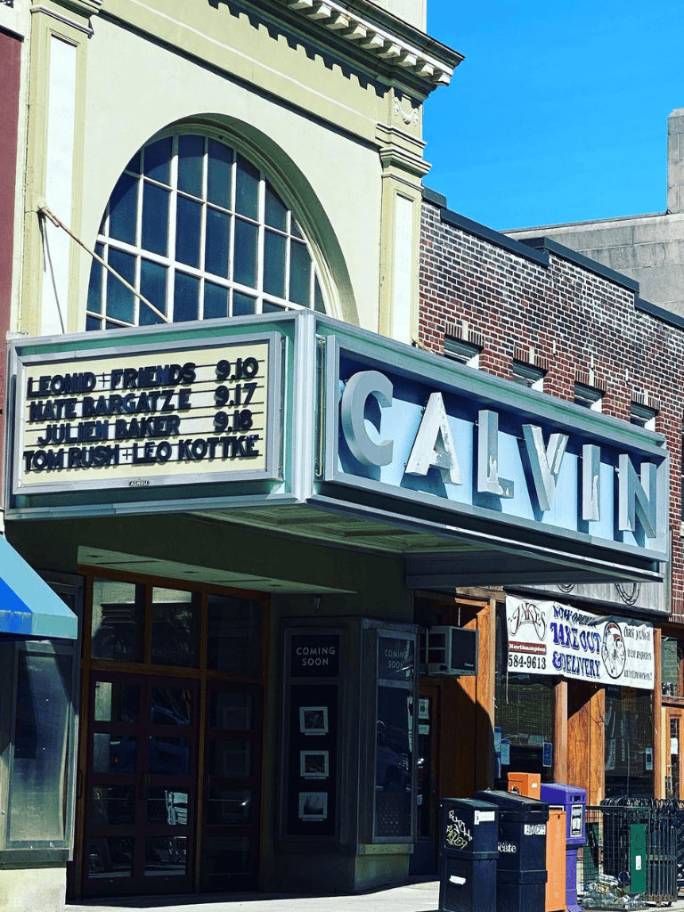 Marquee with "Calvin" sign and upcoming comedy show details in downtown location.