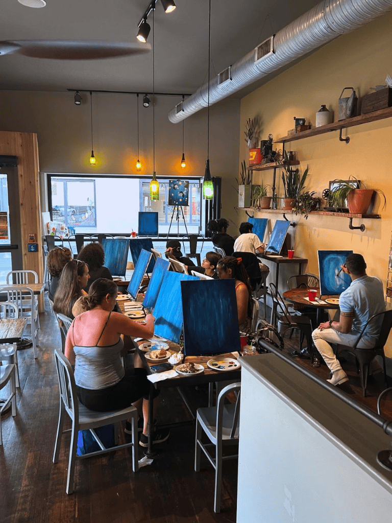 Creative group painting class in cozy café setting for art enthusiasts and beginners.