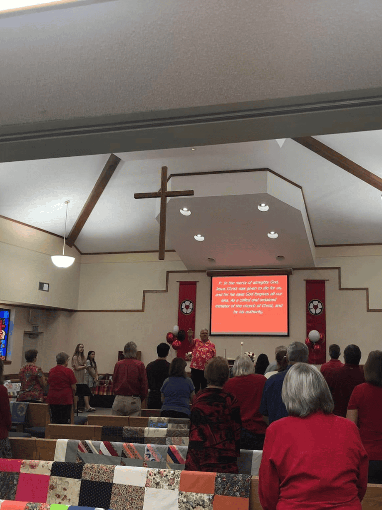 Healing church service in progress with congregation, cross, and altar.