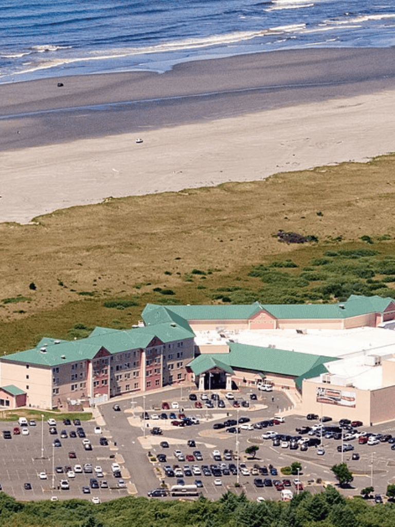 Aerial view of QuestForDirections hotel near the beach and parking lot in a scenic coastal setting.