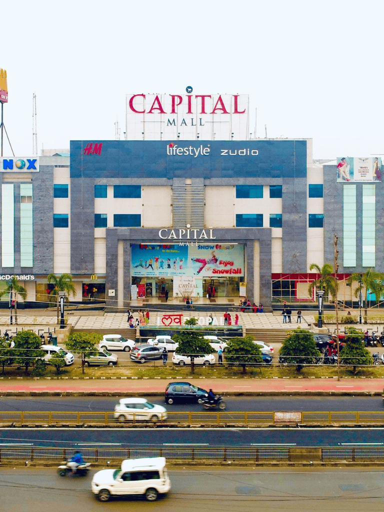 Capital Mall shopping center in city with busy street traffic outside.