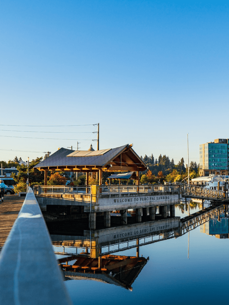 Quintessential pier at Percival Landing in Olympia, Washington, featuring a covered pavilion and scenic water reflections.