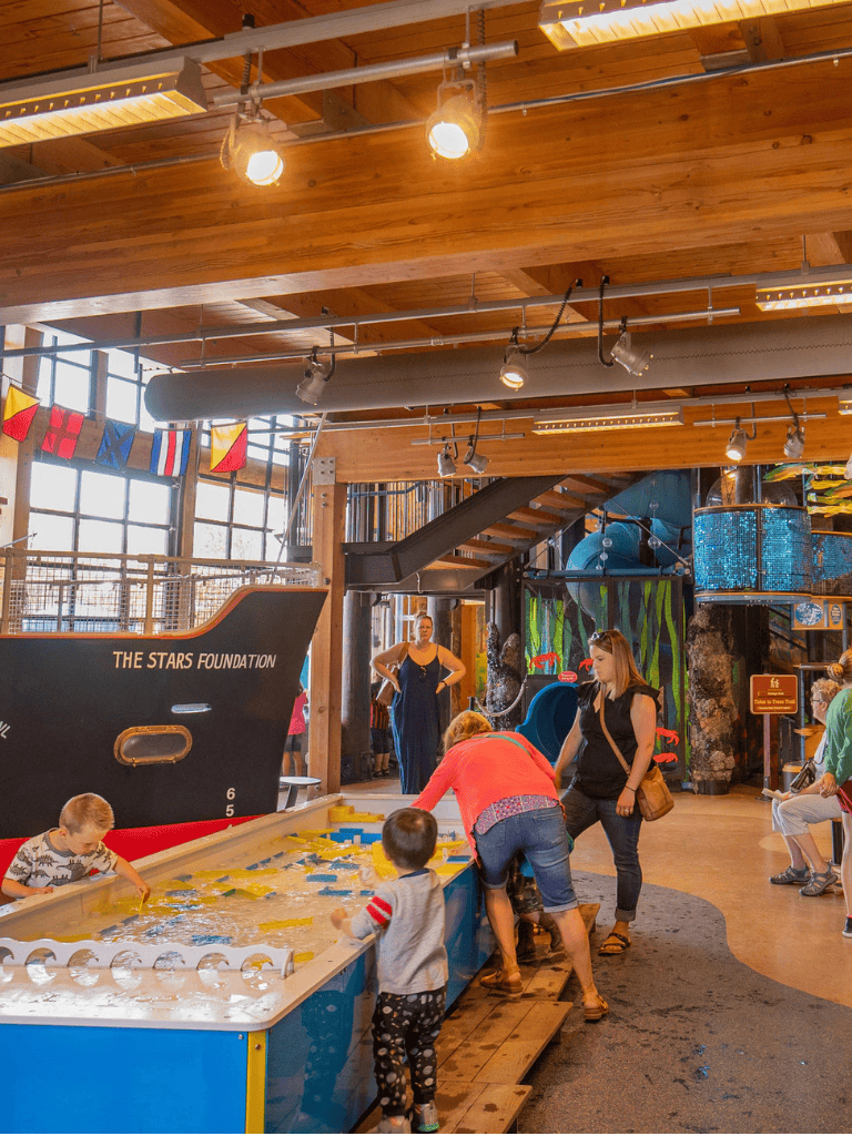 Water-themed kids' play area with boats, slides, and colorful decor inside an indoor entertainment center.