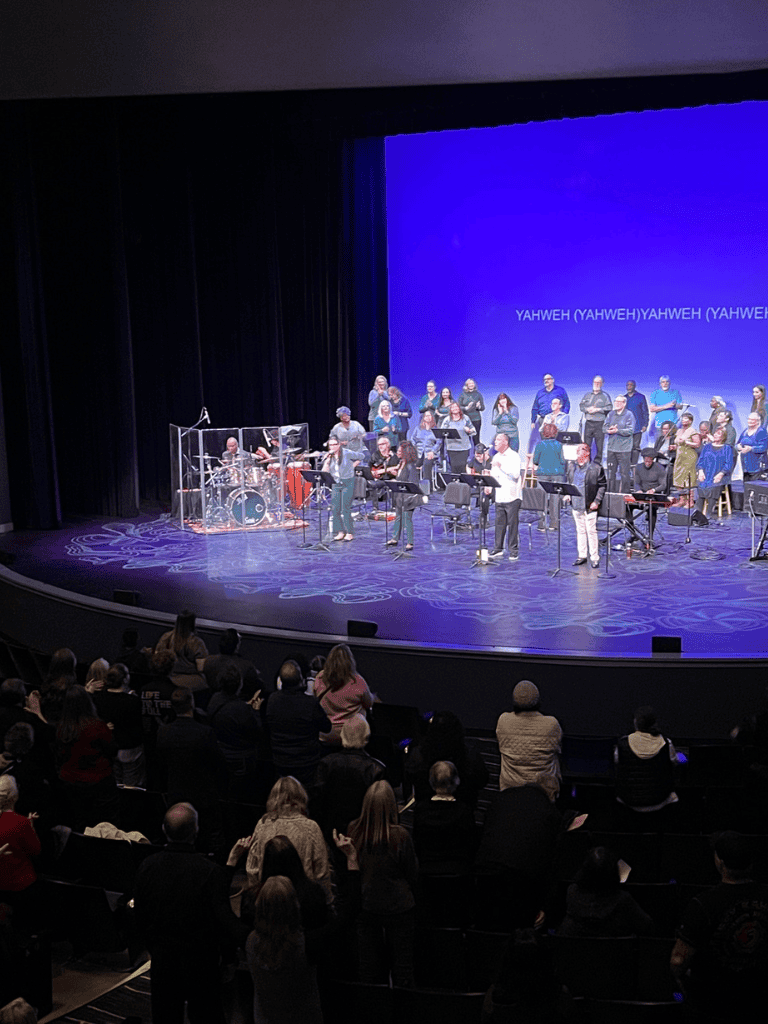 Vibrant church choir performing on stage with audience, dynamic worship service at Quest for Directions.