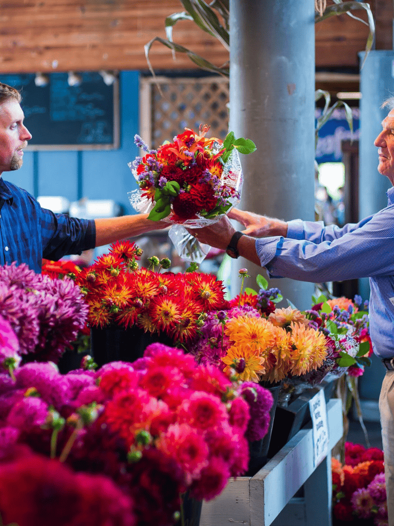 Colorful flower market exchange at QuestForDirections outdoor vendor stall.