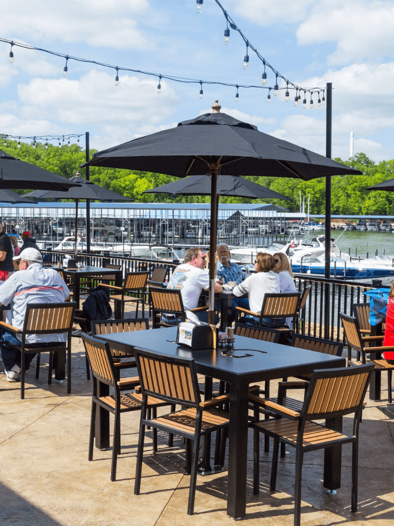 Outdoor waterfront dining with umbrellas and string lights at QuestForDirections marina.