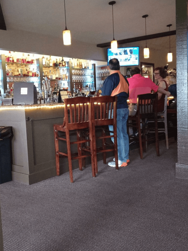 Cozy bar scene with patrons enjoying drinks and televised sports at QuestForDirections, a stylish nightlife venue.