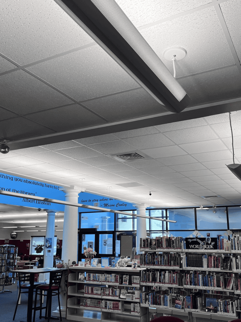 Indoor library with bookshelves, reading areas, and motivational quotes on the walls.