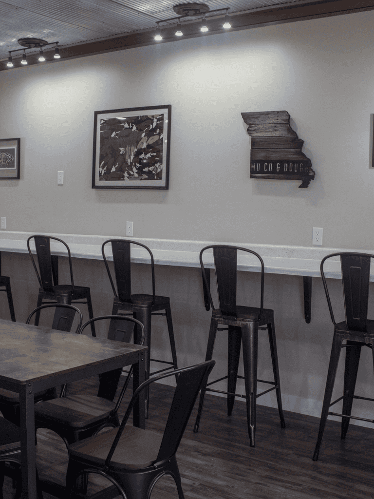 Cozy modern cafe interior with high-top seating and wall art, perfect for casual dining and coffee.