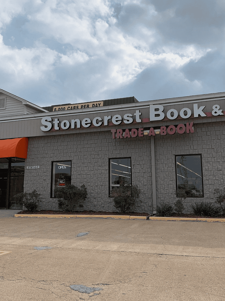 Bookstore in Stonecrest shopping center, trade-a-book store with parking lot and cloudy sky.