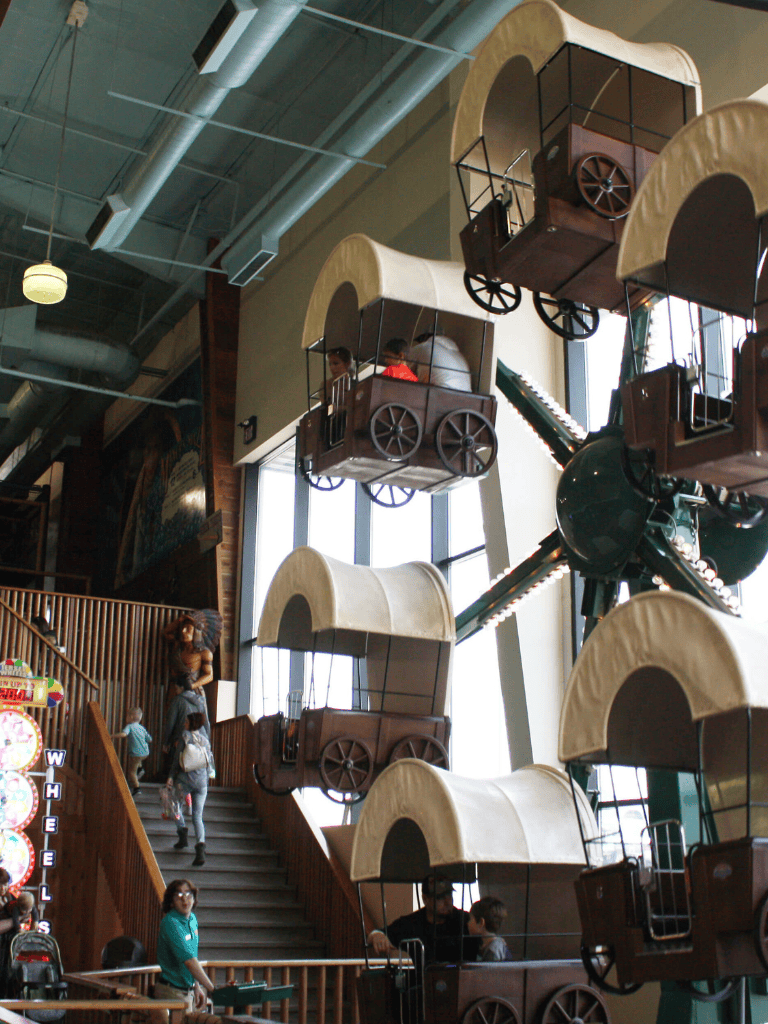 Vintage amusement park rides with Ferris wheel carts at QuestForDirections indoor attraction.