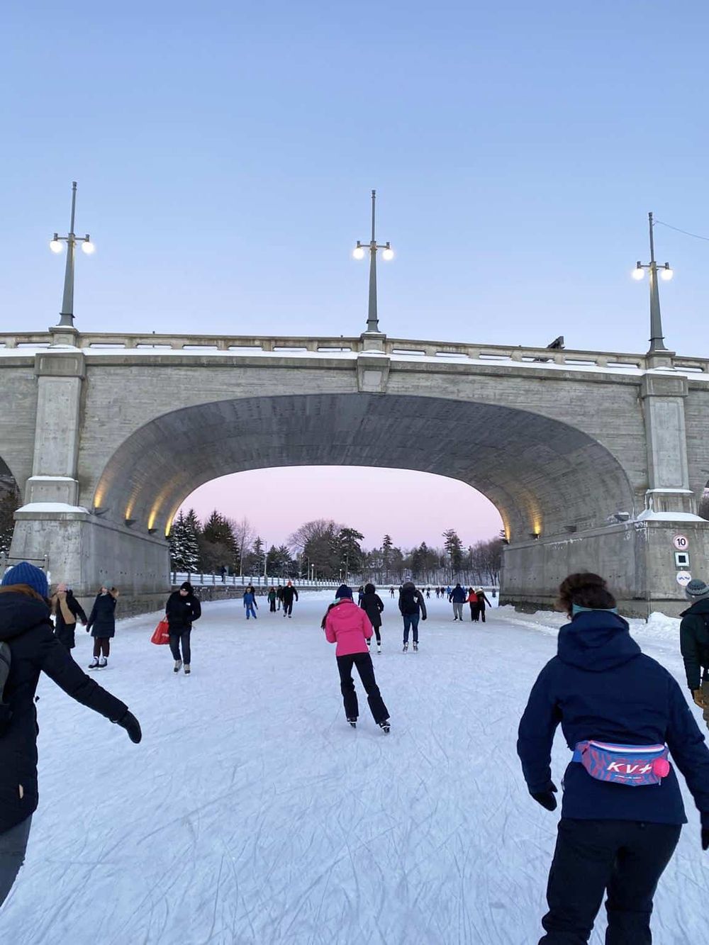 Ice skaters enjoying winter fun under a historic bridge at QuestForDirections.