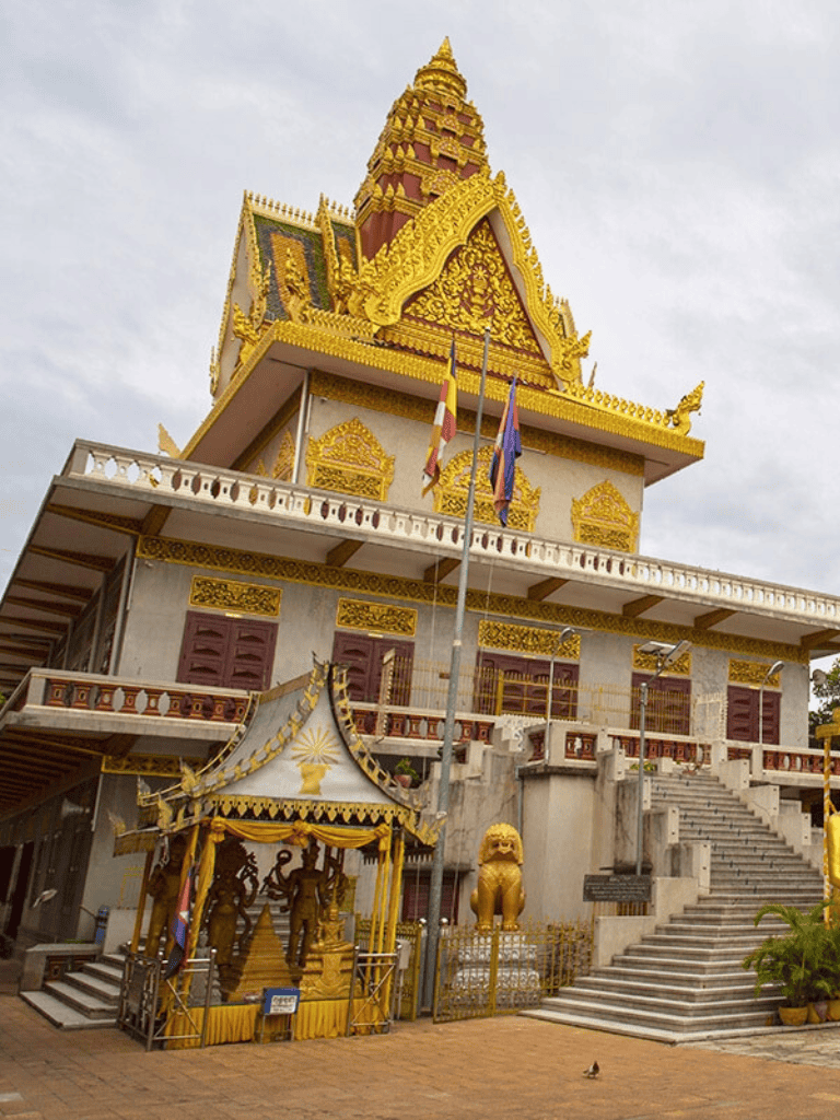 Intricate golden temple with traditional architecture, flags, and statues, representing cultural heritage and religious significance.
